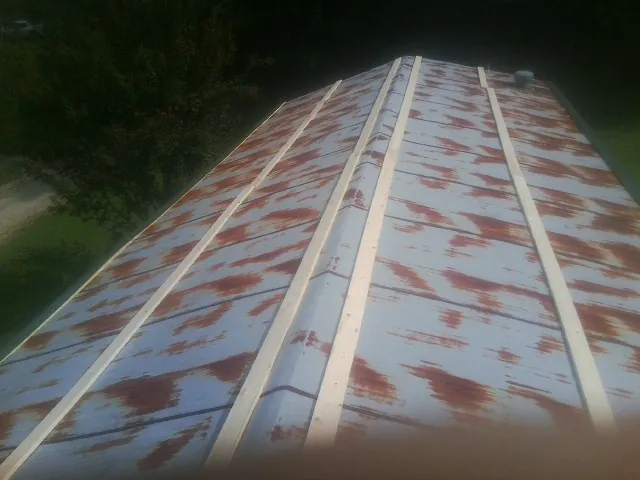Rusted metal roof panels with new wood purlins before replacement — Storm Damage Roof Repair in River Edge by Roofing Brothers
