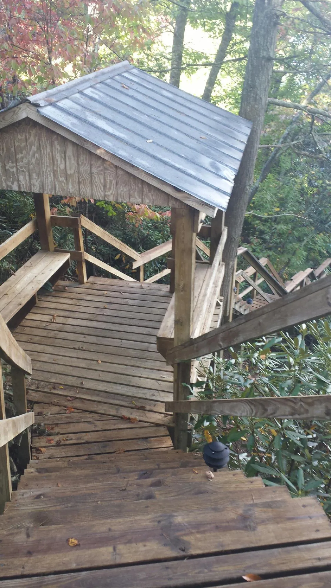 Metal roofed shelter over wooden steps on a wooded walkway — Skylight Repair & Installation work by our crew in River Edge