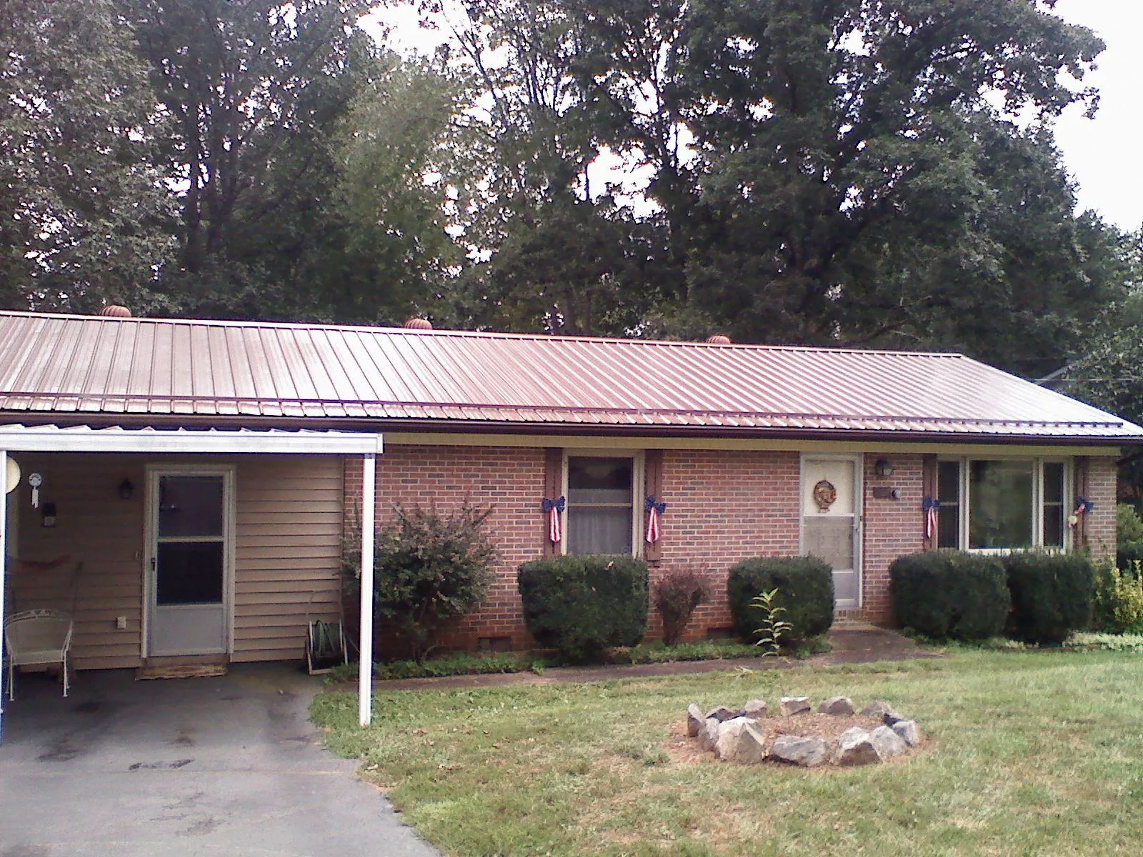 Bronze metal roof and carport on a brick ranch home — Roof Repair work by our crew in River Edge
